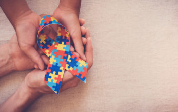 hands-holding-puzzle-ribbon-autism-awareness_49149-551